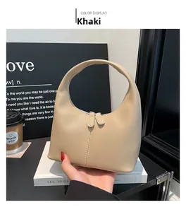 Detail of khaki hobo handbag featuring smooth leather texture and dual zipper closure
