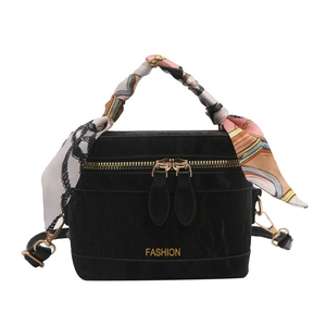 Fashionable black velvet handbag with floral scarf handle and golden zipper