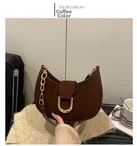 Dettaglio borsa scamosciata marrone caffè con fibbia a D dorata e tracolla a catena spessa