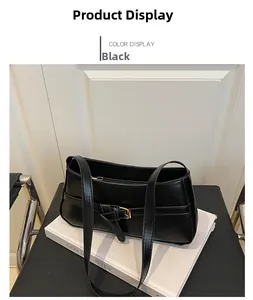 Detail of a black leather underarm bag with gold metal buckle on white background