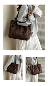 Detail of leopard print tote bag with black woven shoulder strap on model side view