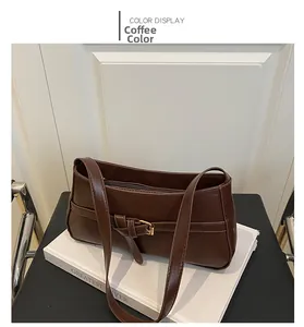 Detail view of coffee brown shoulder bag with gold metal buckle and matte leather texture