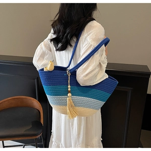 Detail of blue gradient straw tote bag featuring long tassels and large storage capacity