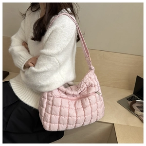 Detail of pink quilted puffer shoulder bag with adjustable strap and silver zipper