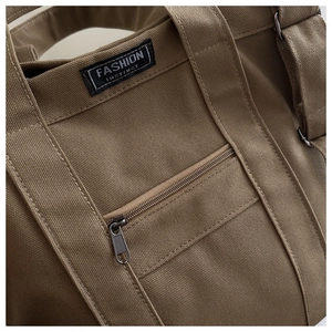 Vue macro de la toile marron avec coutures soignées et détail du zip métallique