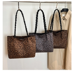 Detailed view of three leopard print tote bags with black braided handles in different tones