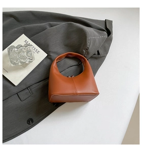 Macro shot of orange leather hobo bag with seamless handle and metallic zipper detail