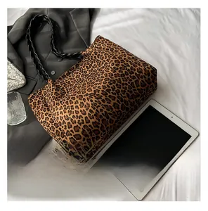 Detail of leopard print tote bag with black handles and spacious interior design