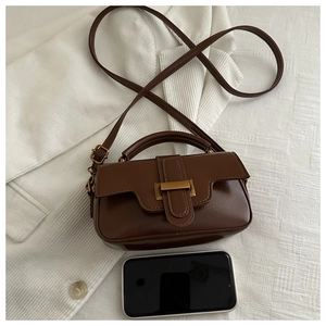 Detailed shot of brown vintage PU leather mini bag with gold buckle and adjustable strap