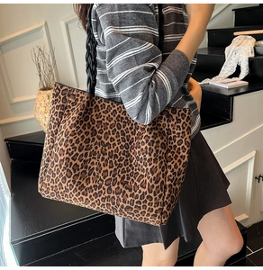 Close-up of vintage leopard print tote bag featuring black woven handles and spacious design