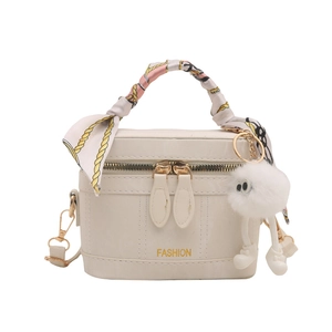 Chic beige bucket bag with silk scarf handle and plush keychain accessory