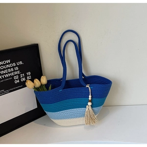 Detail of blue gradient woven tote bag with fringe tassel and wood bead accents