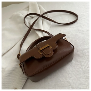 Detail of a brown vintage leather handbag with a gold square buckle and adjustable strap