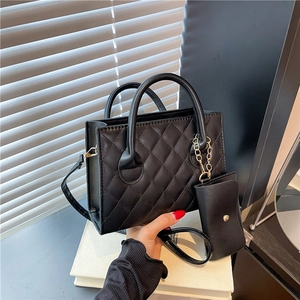 Classic black quilted handbag with matching small pouch on a stylish casual background