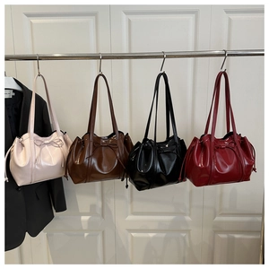 Vier glänzende PU-Lederhandtaschen in Rosa, Braun, Schwarz und Weinrot mit Schleifendekor