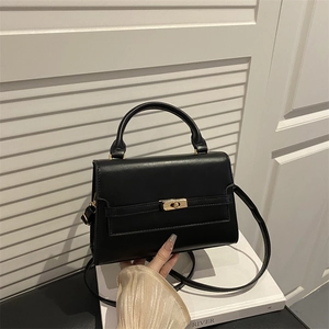 Elegant black leather crossbody bag with gold twist lock on minimalist flap design