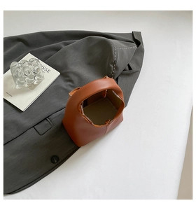 Top view of a brown leather handbag with gold zipper detail and high-quality stitching
