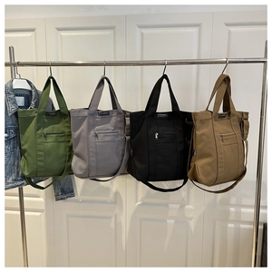 Canvas tote bag in four colors showing front zipper pocket and fashion labels