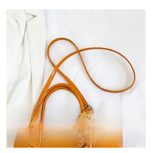 Detail of adjustable shoulder strap and fashion printing on bright orange tote bag