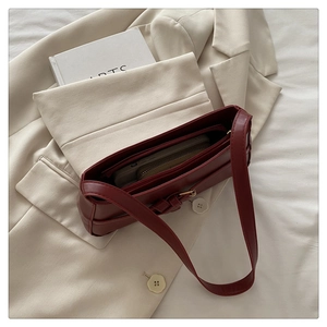 Interior view of burgundy leather baguette bag with multiple compartments and zippers