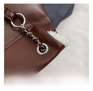 Detail of vintage brown leather backpack with silver chain and white faux fur lining