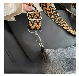 Detail of crossbody bag with monogram print and textured geometric weave shoulder strap
