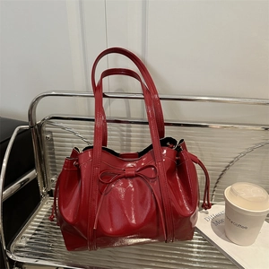 Glossy red patent leather tote bag with bow detail and drawstring closure for women