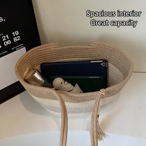 Large woven straw shoulder bag with contrast stripes and tassels for beach vacations