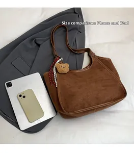 Size comparison of dark brown suede tote bag next to an iPad and a smartphone