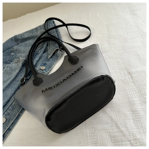 Détail d'un sac cabas transparent avec bandoulières réglables et logo imprimé sur le sac