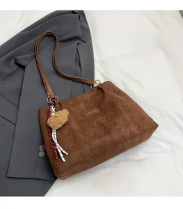 Close-up of brown quilted velvet tote bag featuring a Creative Cat label and bear charm