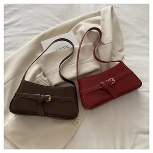 Detail of dark brown and burgundy minimalist shoulder bags with knot and metal buckle