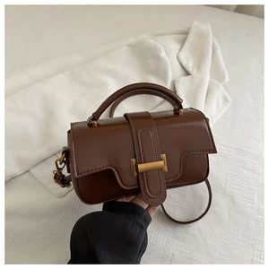 Close-up of a dark brown retro leather handbag featuring a golden rectangular clasp