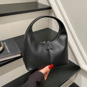 Chic black crescent handbag with smooth leather finish and a stylish curved top handle