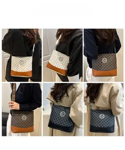 Detail view of stylish crossbody bags with M-letter print and wide geometric shoulder straps
