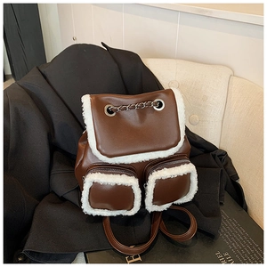 Close-up of brown PU leather backpack with white faux shearling trim and chain detail