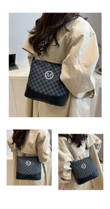Detail of grey bucket bag showing M-pattern texture and stylish woven shoulder strap
