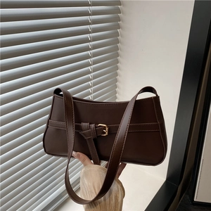 Minimalist deep brown baguette shoulder bag with gold buckle and matte leather texture