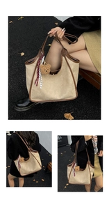Close-up of suede bucket bag featuring contrast leather trim and cute bear charm