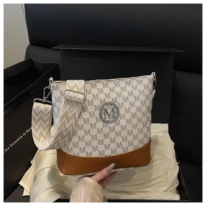 Close-up of stylish letter print handbag in a gift box with silk lining background