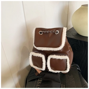 Detail of brown vintage backpack with faux shearling trim and decorative metal chain