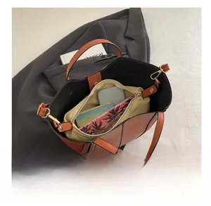 Spacious interior of brown tote bag with canvas insert, showing phone and notebook