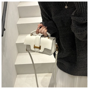Sac bandoulière blanc minimaliste en cuir avec boucle métallique porté par un mannequin