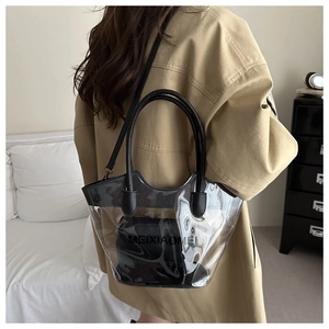 Detailed view of clear PVC tote with black inner pouch on a stylish trench coat model