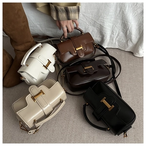 Flat lay of five high-gloss leather bags with gold H buckles in brown, cream, and black