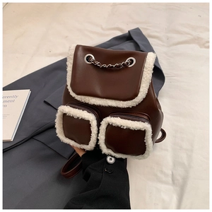 Detail of coffee brown faux leather backpack with plush sheepskin texture and chain links