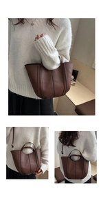 Detail of dark brown leather bucket bag showing stitching and detachable strap versatility
