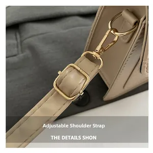 Détail de la bandoulière réglable et fermoir doré sur sac beige à motif croco