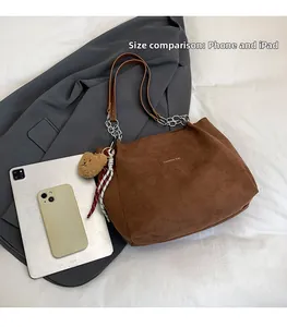 Détail montrant la capacité du sac avec téléphone et tablette dans un cabas marron