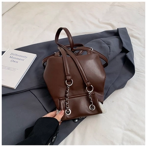 Detail of dark brown PU leather mini backpack with silver chains and plush trim